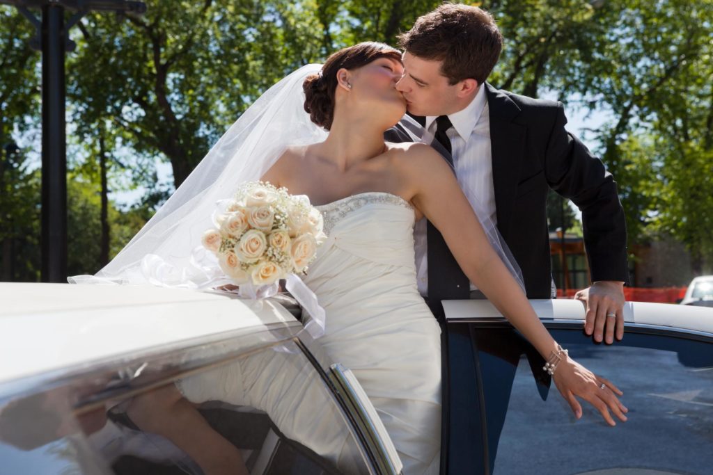 wedding picture kissing bride and groom on limousine